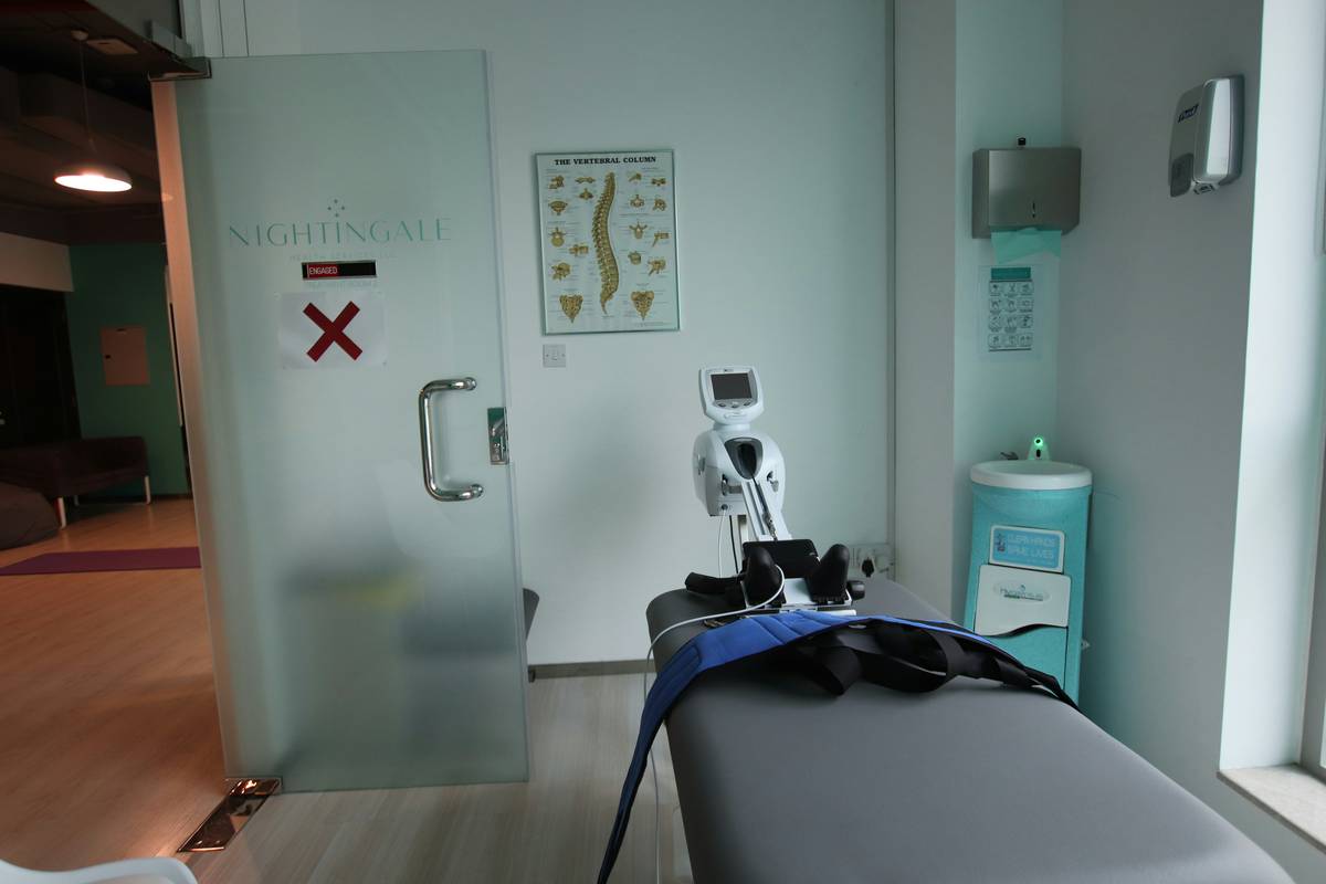 pain management tools for nurses including foam rollers, resistance bands, and ergonomic braces laid out on a hospital cart
